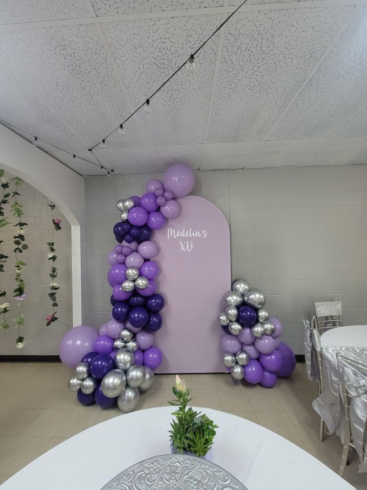 Backdrop set up for a Quinceñera with different shades of purple as the balloon colors Purple Silver Balloon Garland, Blue And Purple Balloon Arch, Purple Balloon Arch Backdrop, Purple White And Silver Party Decor, Purple Balloon Decoration, Purple Balloon Decor, Purple And Silver Balloon Garland, Purple Balloon Decorations, Purple And Gold Balloon Garland