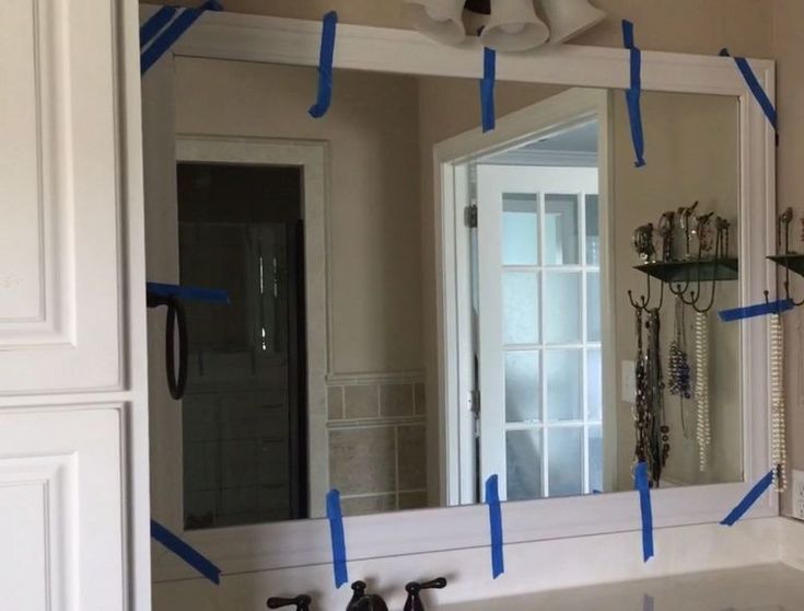 a bathroom mirror with blue tape taped around it