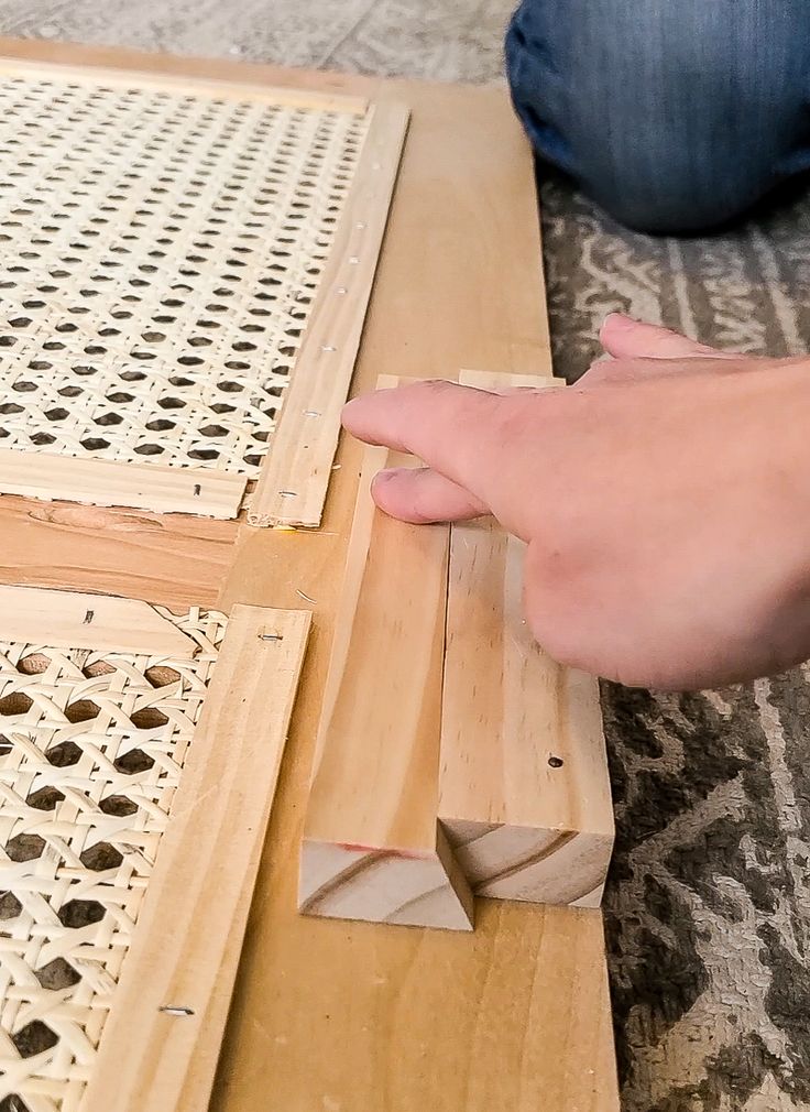 a person is working on a wooden table with holes in the top and bottom part