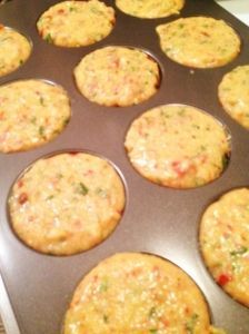 a muffin tin filled with mini pizzas on top of a stove