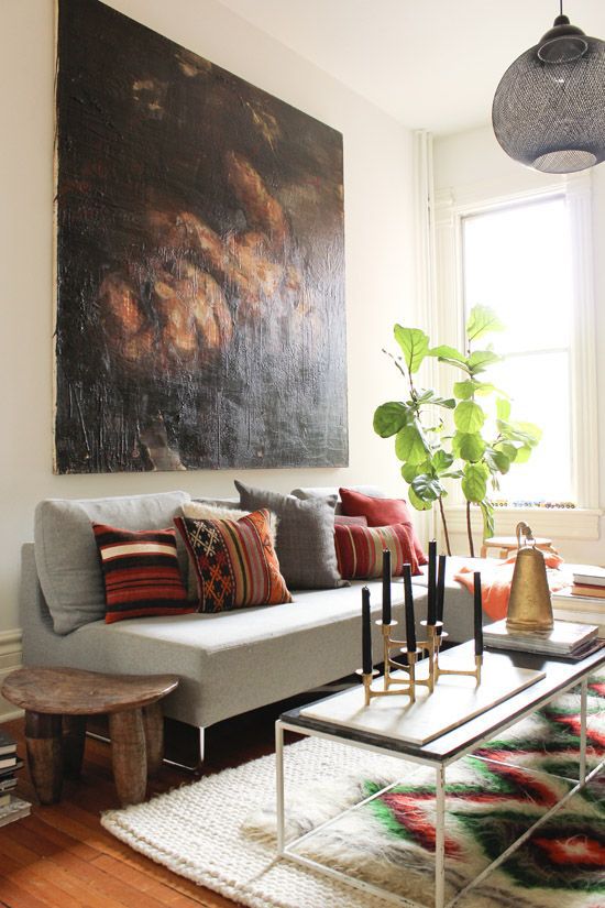 a living room filled with furniture and a painting on the wall