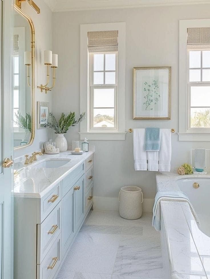 a white bathroom with two windows and a bathtub