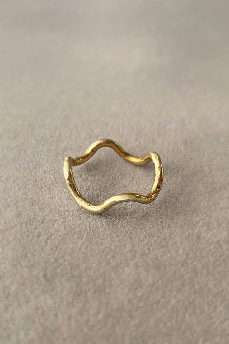 This minimal ring features a gentle, undulating movement around the finger. The subtle dips and rises of a single strand of brass offer a rhythmic reminder of her name, Kundalini. A delicate, yet curiously captivating adornment. Sister style of the Kundalini Earrings. Elegant Brass Stackable Rings Hand Forged, Minimalist Hand Forged Gold Midi Rings, Elegant Hand Forged Brass Stackable Rings, Minimalist Brass Stackable Toe Rings, Handmade Spiral Minimalist Rings, Minimalist Stackable Wavy Rings, Minimalist 14k Gold Spiral Ring, Kundalini Kriya, Adjustable Brass Spiritual Ring