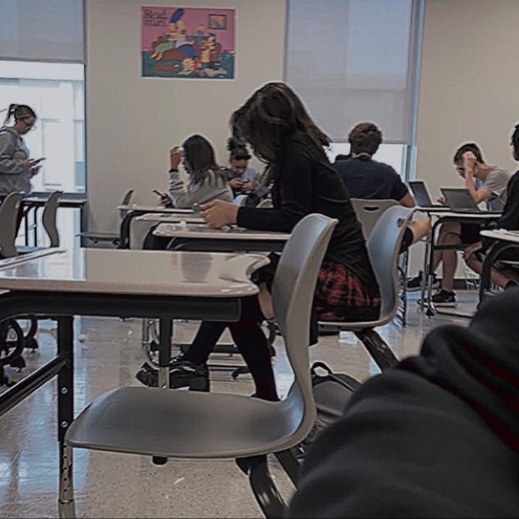 people sitting at desks in a classroom with their backs turned to the same direction