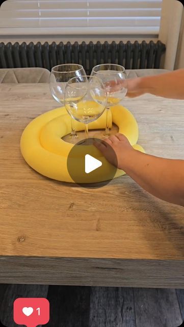 a person is pouring wine into glasses on a banana shaped table with an air vent