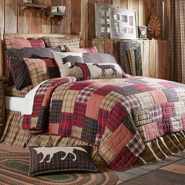 a bed covered in plaid comforter and pillows