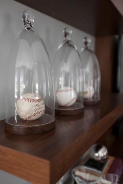 three glass domes with baseballs in them on a shelf