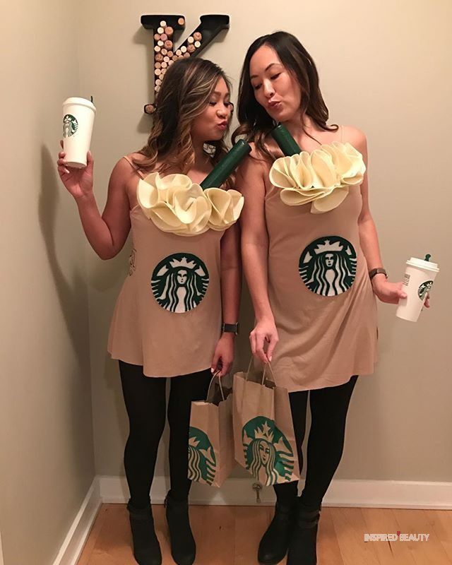 two women dressed in starbucks outfits holding starbucks bags