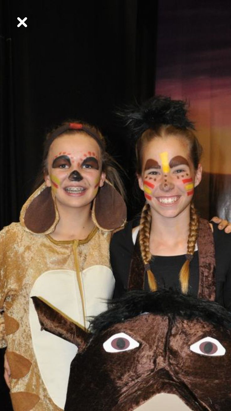 two children in costumes standing next to each other with their faces painted like animals and horses