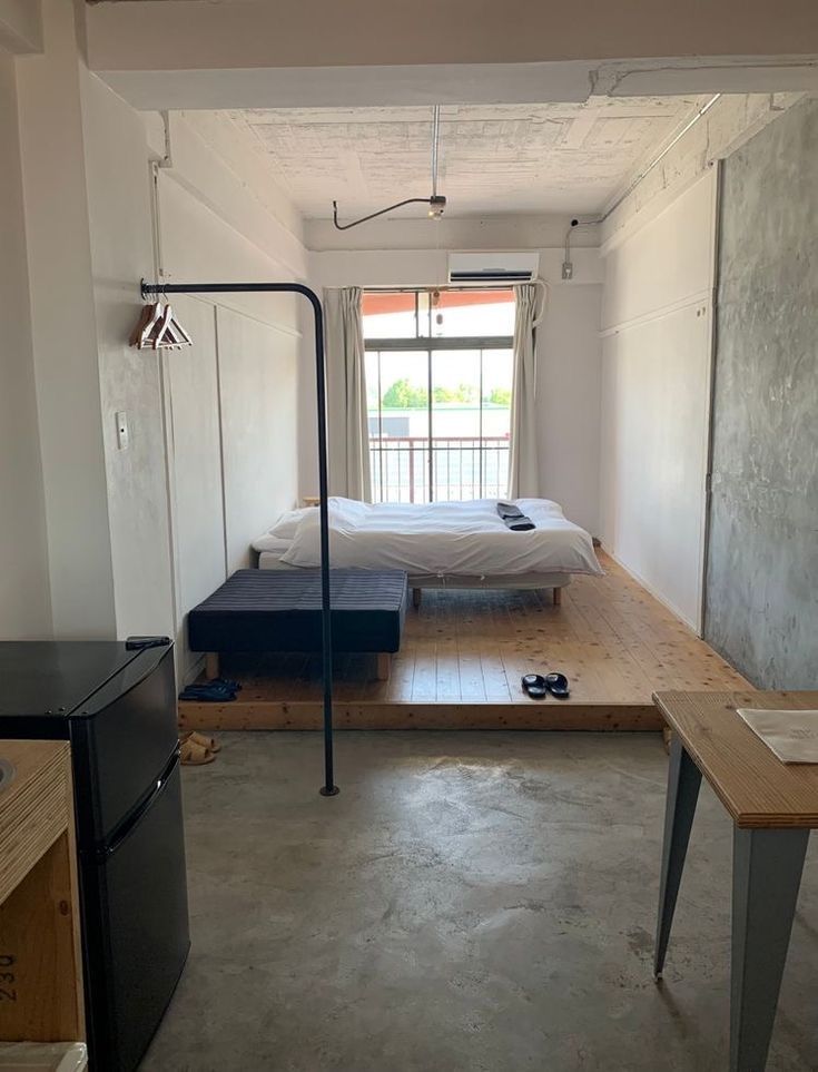 an empty room with a bed and desk in it