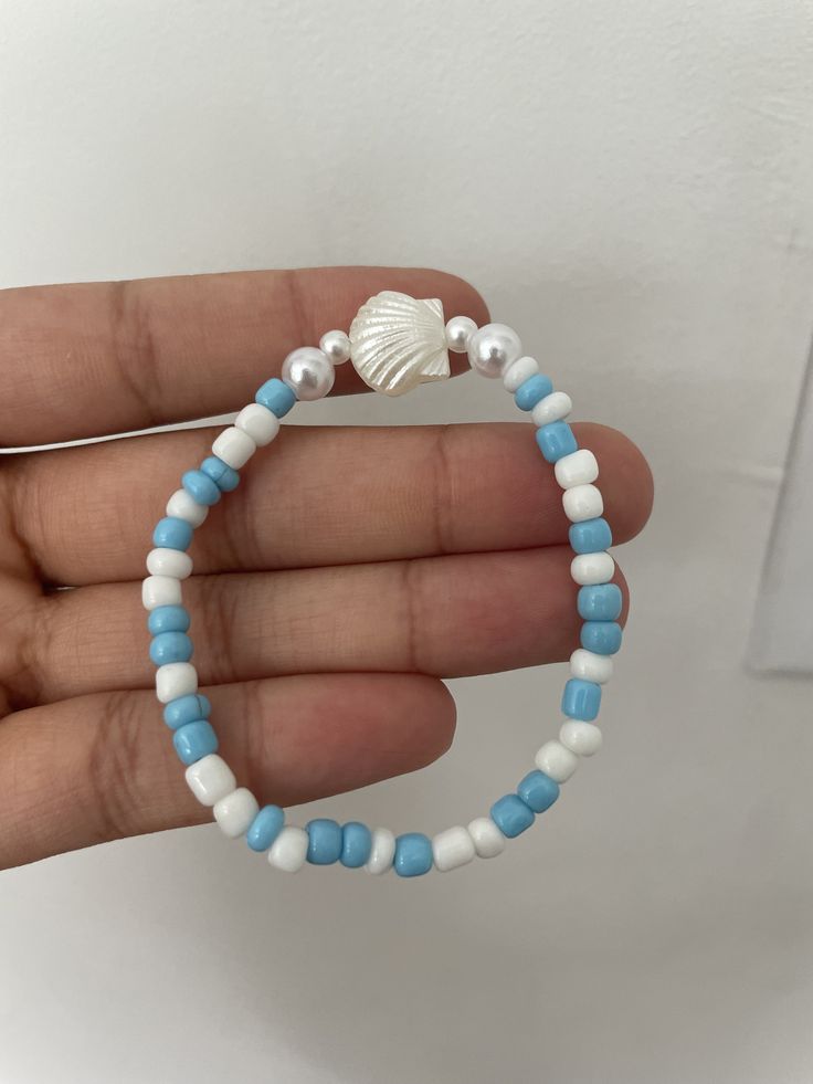 a bracelet with a shell and blue and white seed beads to match the ocean and foam! White Beaded Beachy Bracelet, Handmade White Pearl Bracelet For The Beach, Beachy White Beaded Bracelet, White Shell-shaped Beaded Bracelets For Vacation, White Beaded Pearl Bracelet For Vacation, White Beaded Pearl Bracelet For Beach, White Round Beads Ocean-inspired Bracelets, White Shell Beaded Strand Bracelets, White Beaded Shell-shaped Bracelets