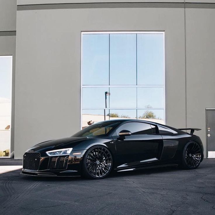 a black sports car parked in front of a building