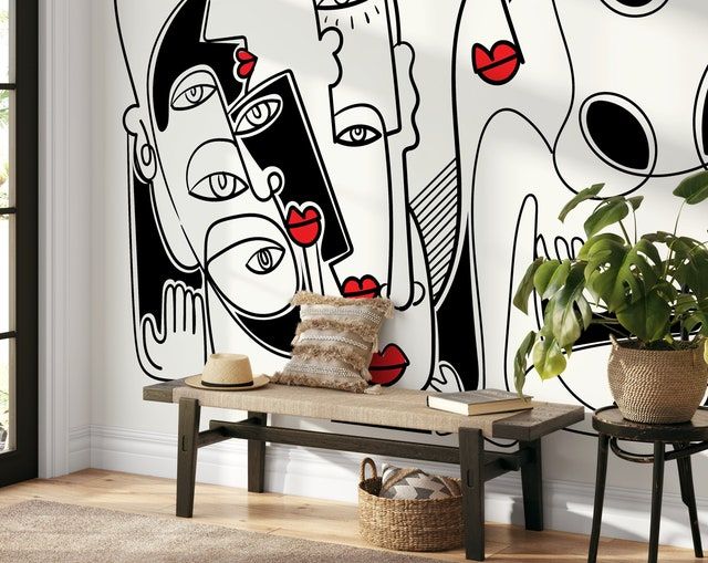 a living room with a large mural on the wall next to a chair and potted plant