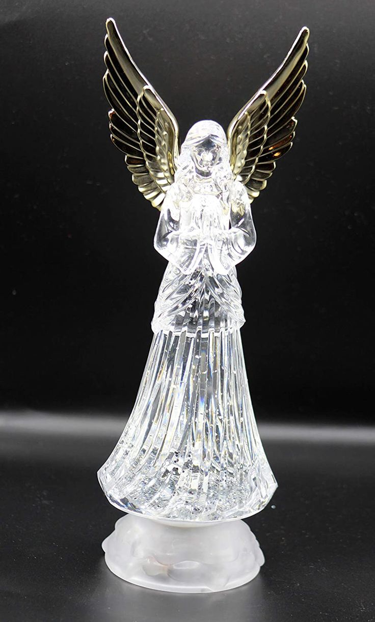 an angel figurine is shown on a black surface