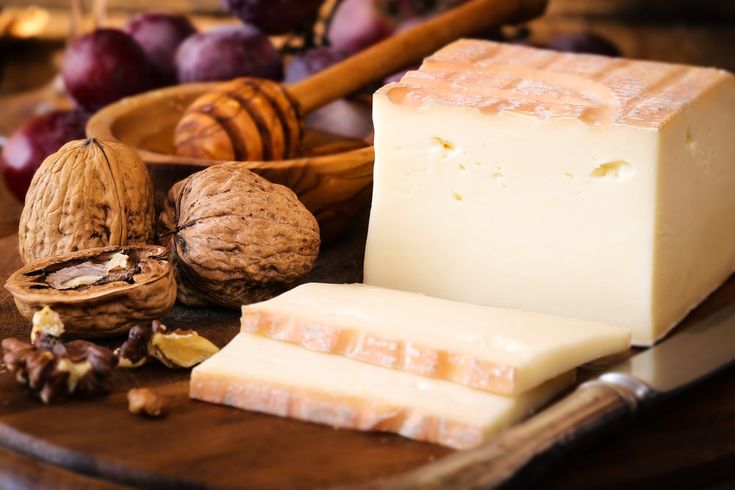 cheese, nuts and honey on a cutting board