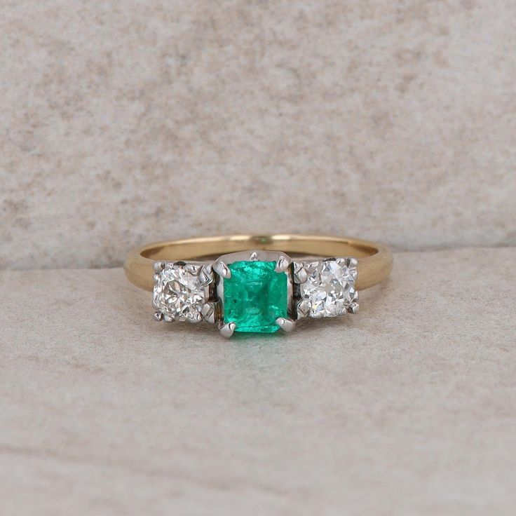 This 14k yellow gold ladies ring has three stones that are set in 14k white gold heads. A green emerald at the center that measures approx 4.5x5.5mm. The emerald is fracted and abraided. The two round diamonds on each side measures approx 0.46ctw together. The color is light brown and the clarity is I1. The ring weighs 3.42 grams and the finger size is 7.75. Condition: Pre-Owned *All items are thoroughly inspected for quality assurance purposes Green Three-stone Emerald-cut Emerald Ring, Green Three Stone Emerald Cut Emerald Ring, Three-stone Emerald Cut Green Emerald Ring, Green Emerald Cut Three Stone Emerald Ring, Heirloom Green Emerald Ring With Three Stones, Heirloom Style Three Stone Green Emerald Ring, Heirloom Three-stone Emerald Ring, Green Emerald Three Stone Ring In 14k Gold, Three-stone Emerald Cut Emerald Ring For Anniversary