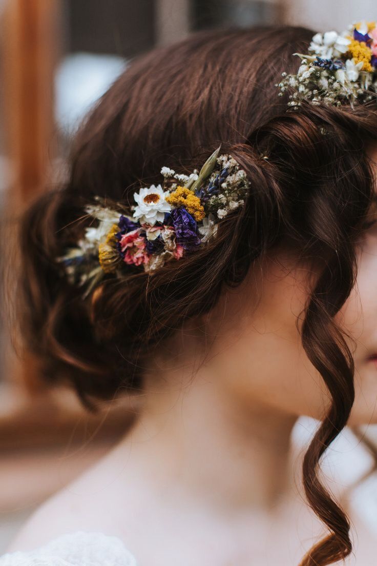 a close up of a woman with flowers in her hair wearing a flower headband