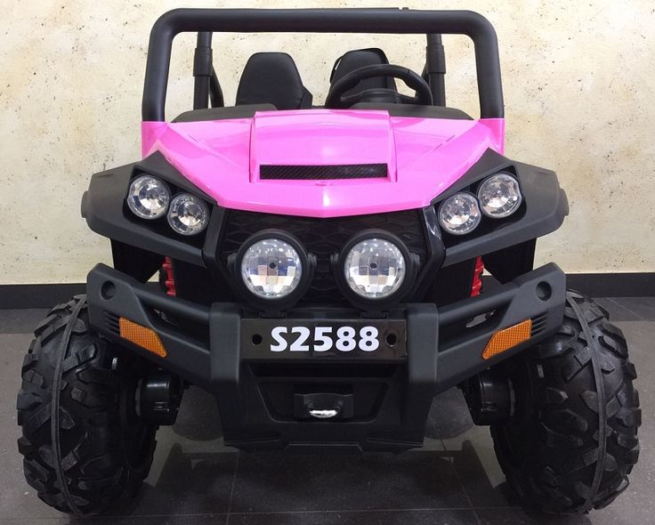 a pink four - wheeled vehicle parked in a room