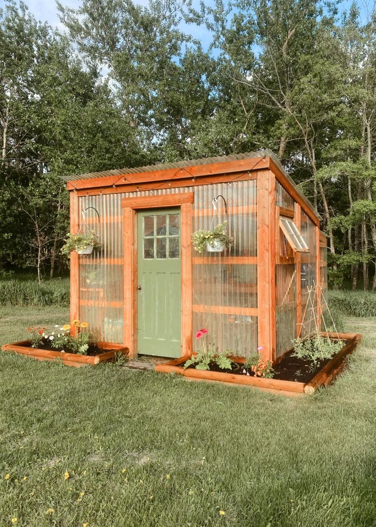 a small garden shed in the middle of some grass