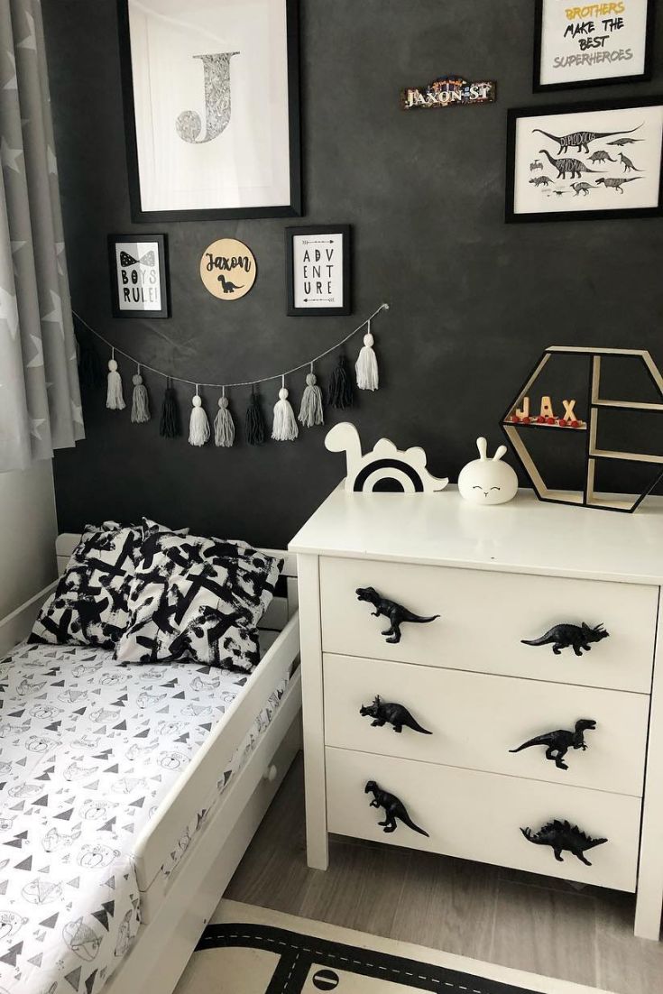 a white dresser sitting next to a bed in a room with pictures on the wall