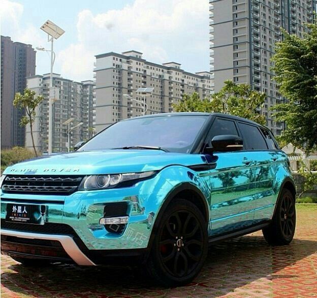 a blue range rover parked in front of some tall buildings