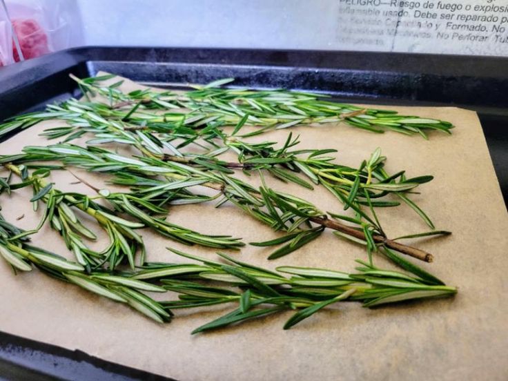 some green herbs are laying on a piece of parchment paper in the process of being cooked