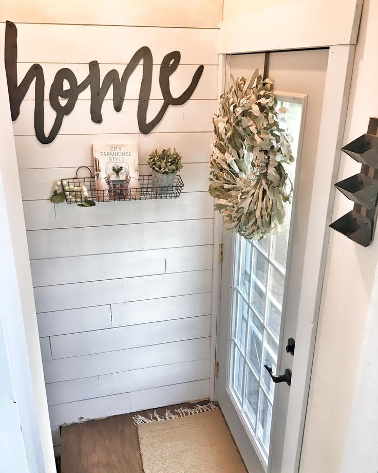 a door with the word home painted on it next to a welcome mat and wreath