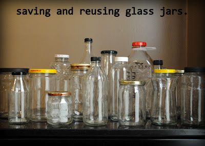 there are many glass jars lined up on the shelf with one empty bottle in front