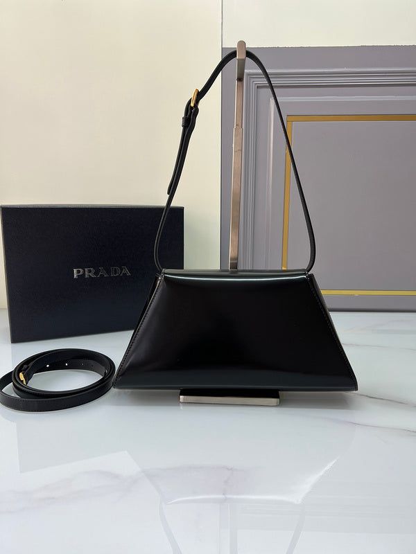 a prada bag sitting on top of a white table next to a black box