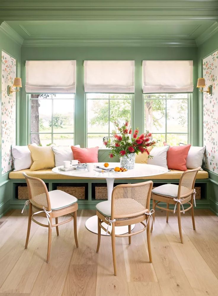 a dining room with green walls and wooden floors