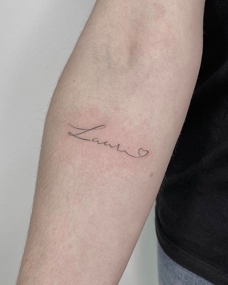 a person with a tattoo on their arm that says,'love'in cursive writing