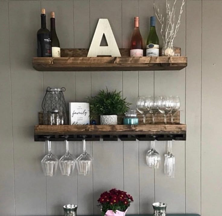 a teal dresser with wine glasses and flowers on the top shelf next to it