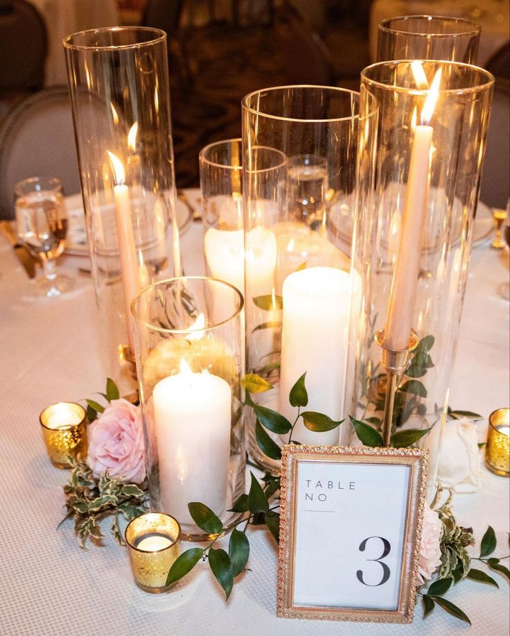 a table topped with candles and flowers next to a number three sign on top of a table