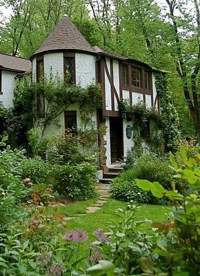 a white and brown house surrounded by greenery