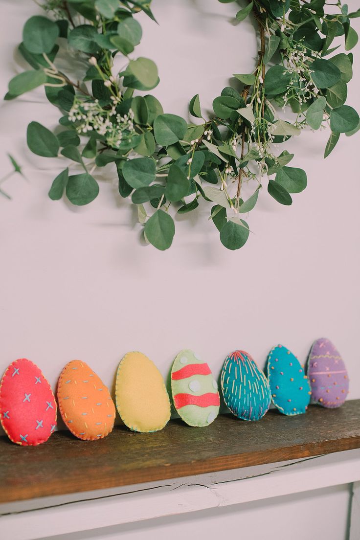 an arrangement of painted eggs sitting on a shelf