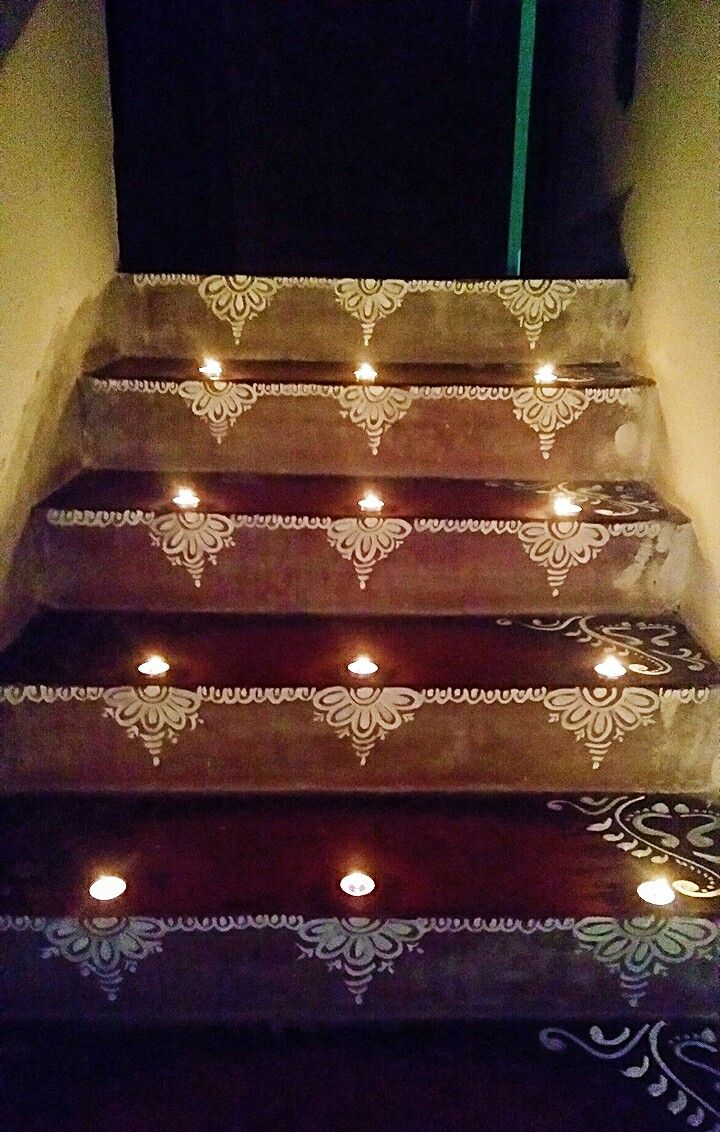 candles are lit on the steps in front of an open door and carpeted floor