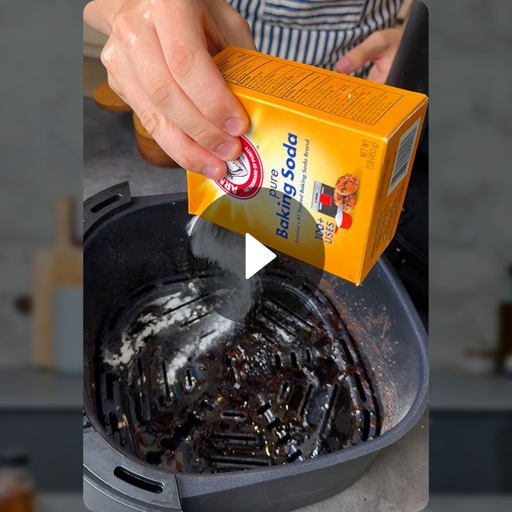 a person pouring something into a pot with food in it and a box on the side