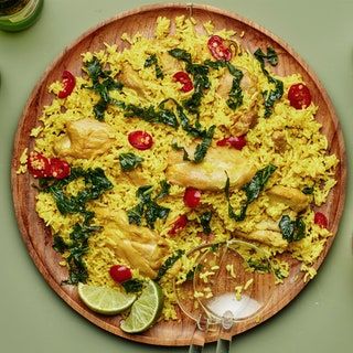 a wooden plate topped with rice and chicken