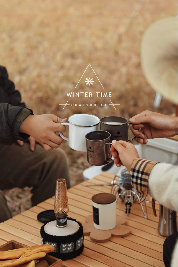 two people holding coffee cups while sitting at a table with other people around them and the words winter time on it