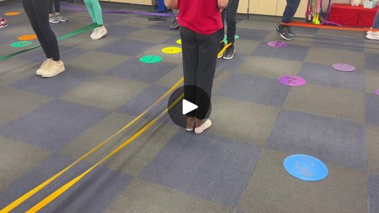 a group of people standing in a room with circles on the floor