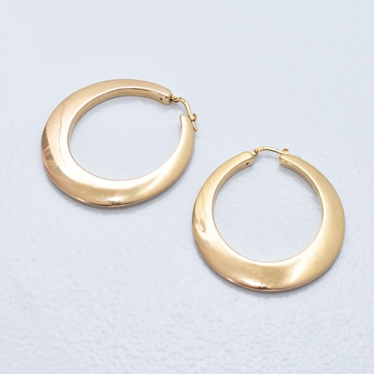 A stunning pair of vintage Italian 14k yellow gold oval hoop earrings. These elegant earrings exude timeless sophistication and charm. Crafted in Italy, these hoops feature a graduated oval shape and are made from high-quality 14k yellow gold with a clean polished finish. With their vintage appeal and versatile design, these earrings are the perfect accessory for both casual and formal occasions.  There are a few minor dents to the gold facade, but nothing that takes away from the overall aesthetic (see photos). The latch-back posts have been hallmarked 'Italy 14K', and the gold has been acid-tested for authenticity. In good vintage condition with age-appropriate wear and discoloration.  **This listing contains photographs of the actual item you will receive. Please look closely at the pic Oval Hoop Earrings Fine Jewelry For Formal, Oval Hoop Earrings Fine Jewelry For Formal Events, Oval Hoop Earrings Fine Jewelry For Formal Occasions, Oval Hoop Earrings For Formal Occasions, Timeless Oval Everyday Earrings, Timeless Oval Earrings For Everyday, Luxury Oval Hoop Earrings, Elegant Rounded Tarnish Resistant Earrings, Elegant Yellow Gold Oval Link Hoop Earrings