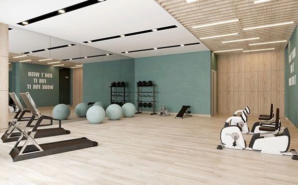 there are many exercise equipment in the gym with blue walls and wood flooring,