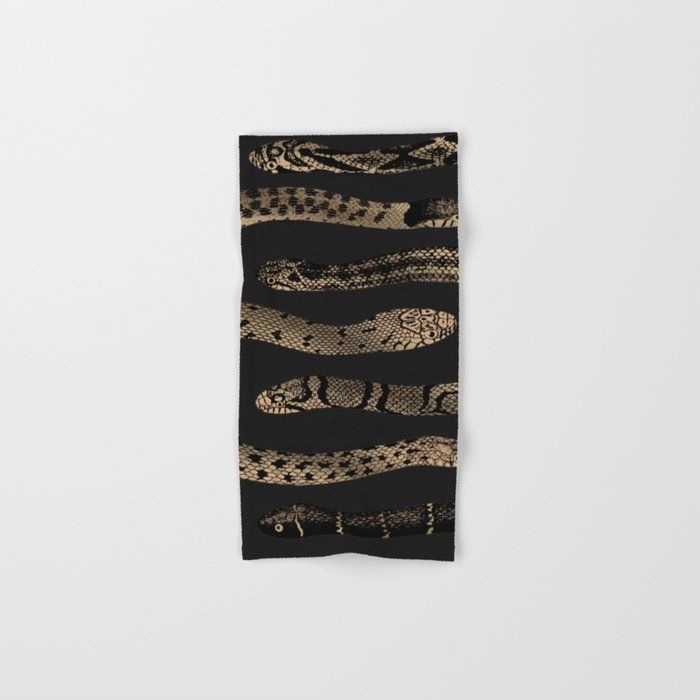 a black and gold scarf with snake skin on it, hanging from the wall in front of a white background