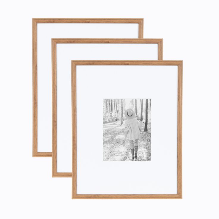 three wooden frames with a black and white photo in the middle one has a person walking