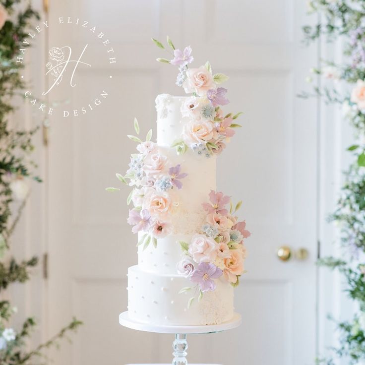 a white wedding cake with pink and purple flowers