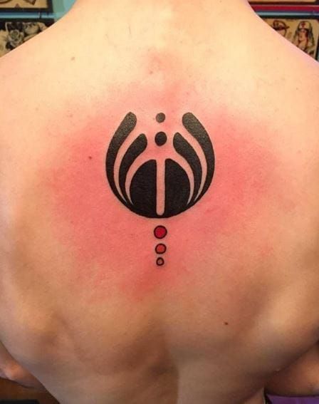 the back of a man's shoulder with a black and red tattoo on it