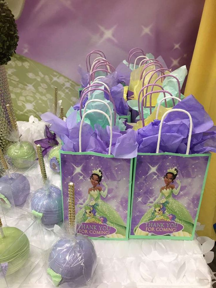 there are many bags with princess and the frog on them sitting on a white table