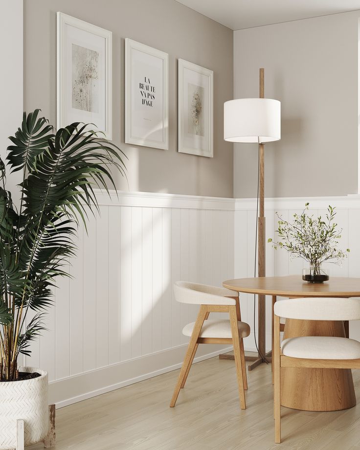 a dining room table with two chairs and a potted plant in the corner next to it