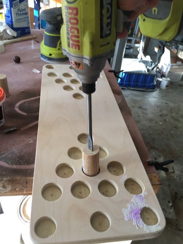 a drill is being used to make holes in a piece of wood that has holes cut into it