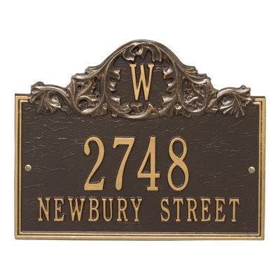 a sign that says newbury street with the letter w in gold and black on it